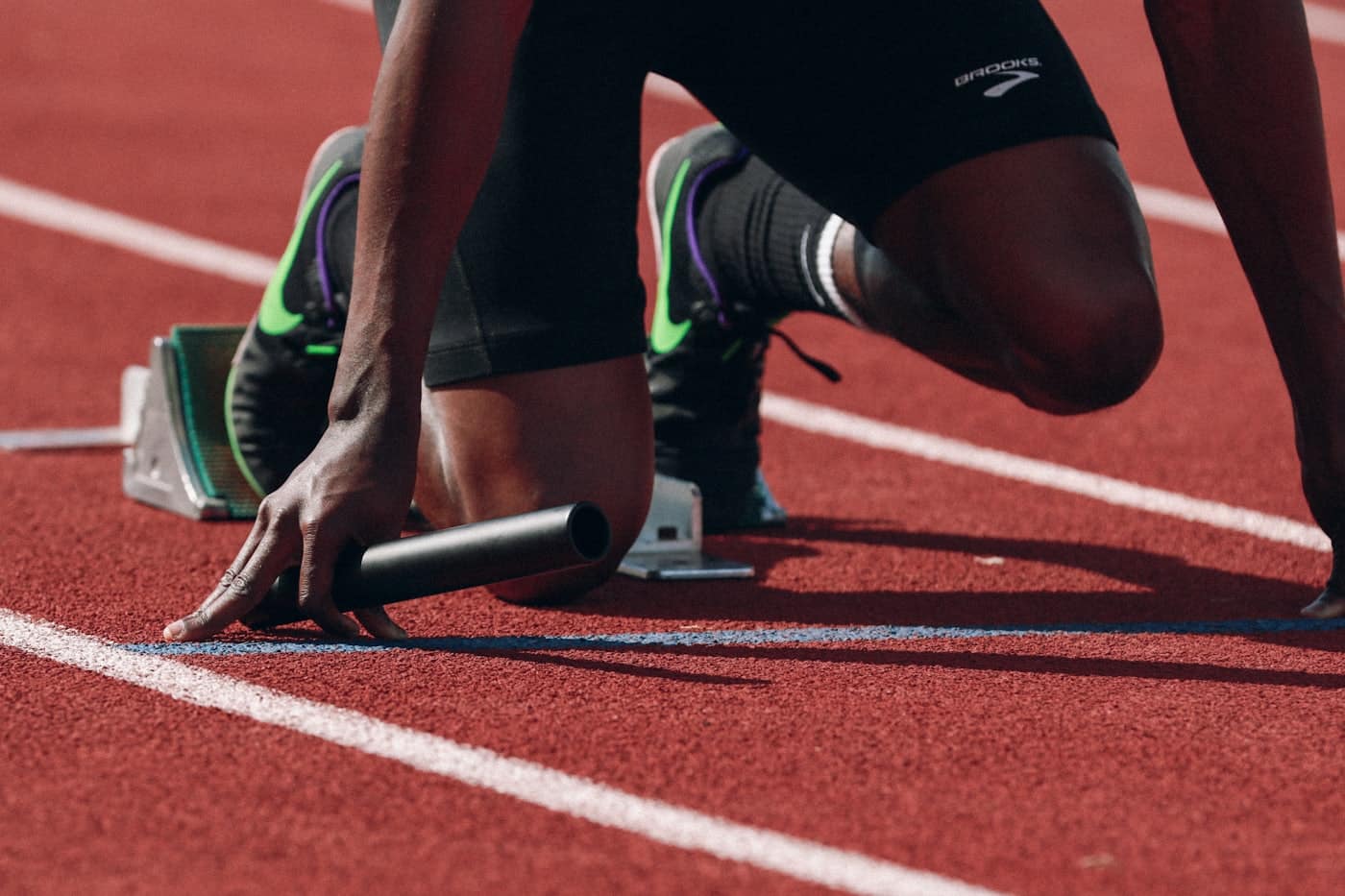 Sprinter im Startblock, im konzentrierten Moment kurz vor dem Loslaufen.